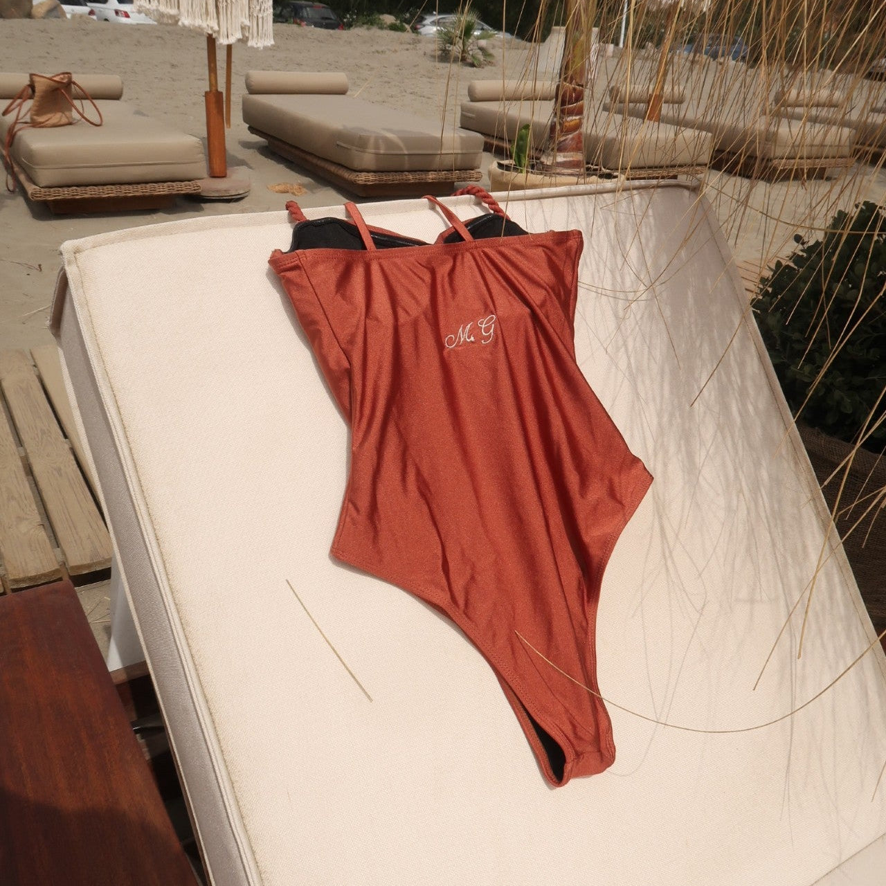 personalised swimsuit in brown on a sun bed at a beach