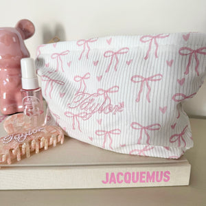 Pink bows wash bag on jacquemus book with personalised name on bag