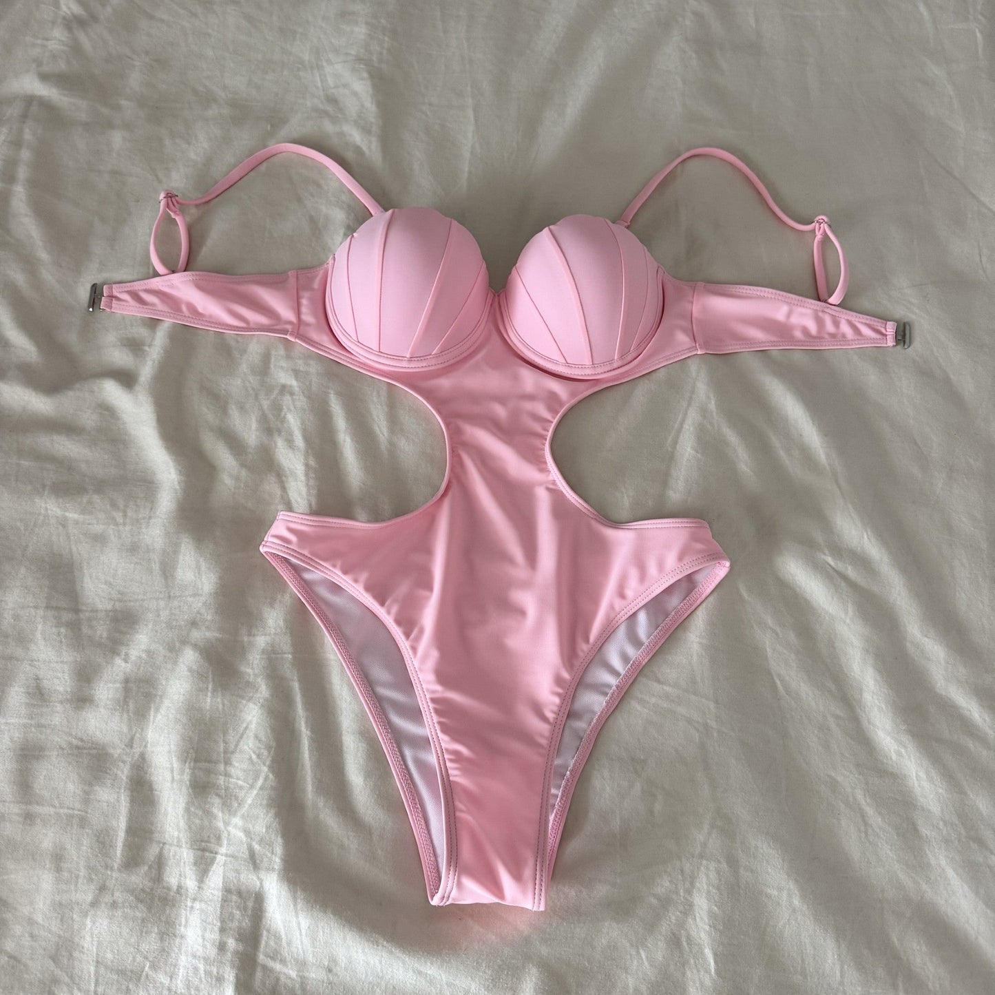 Pink bikini set on a light gray fabric background