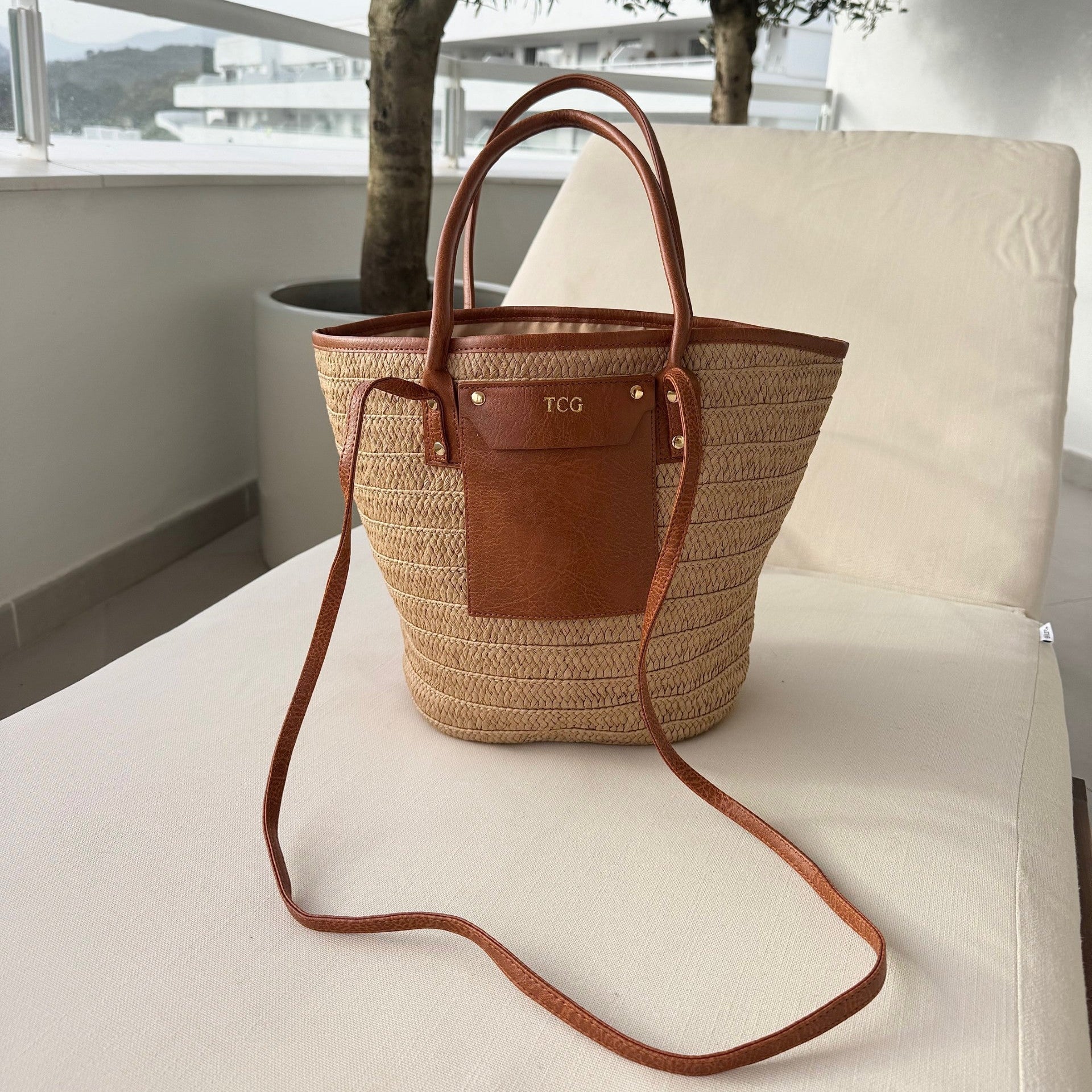 Woven bag with leather accents on a white chair outdoors