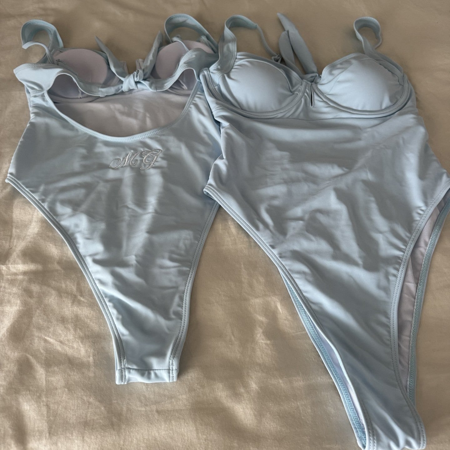 Blue swimsuit set on a beige surface