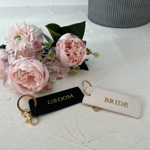 Keychains labeled 'Groom' and 'Bride' .