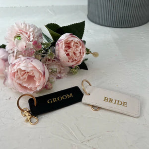 Keychains labeled 'Groom' and 'Bride' .