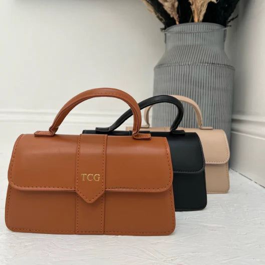 Three small handbags in brown, black, and beige personalised