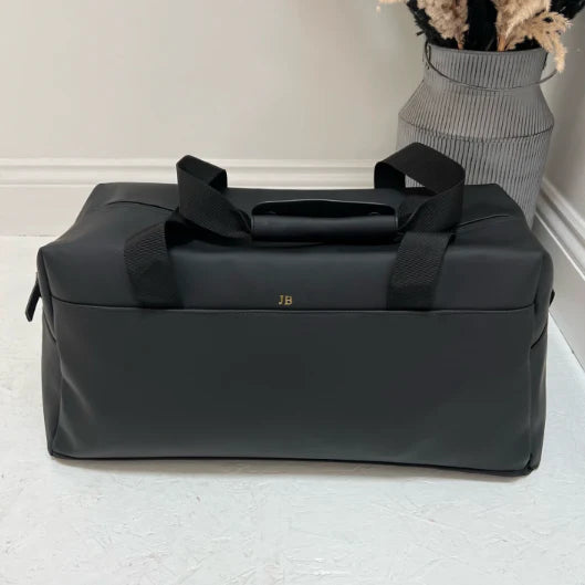 Black travel bag with 'JB' from different angle