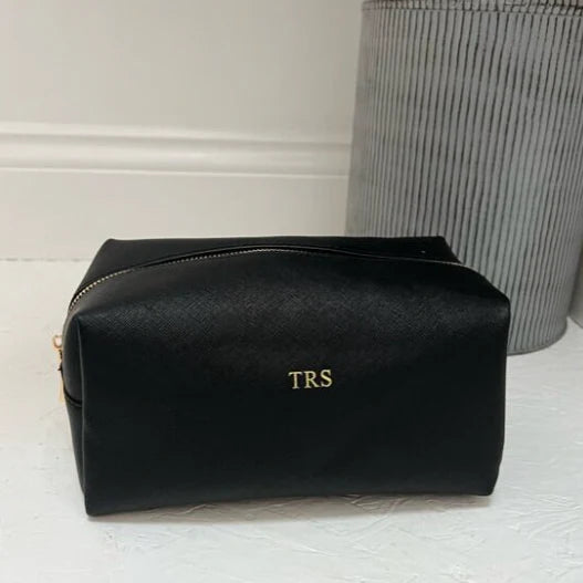 Black toiletry bag with 'TRS' initials 