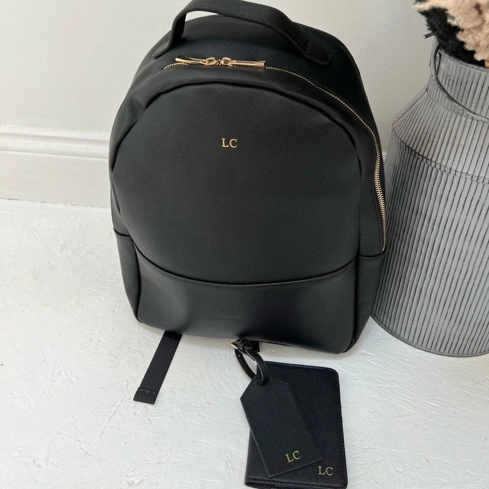 Black backpack with gold initials LC with matching travel set
