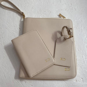 Personalised travel document wallet in beige. Image shows the product with a matching passport holder and luggage tag