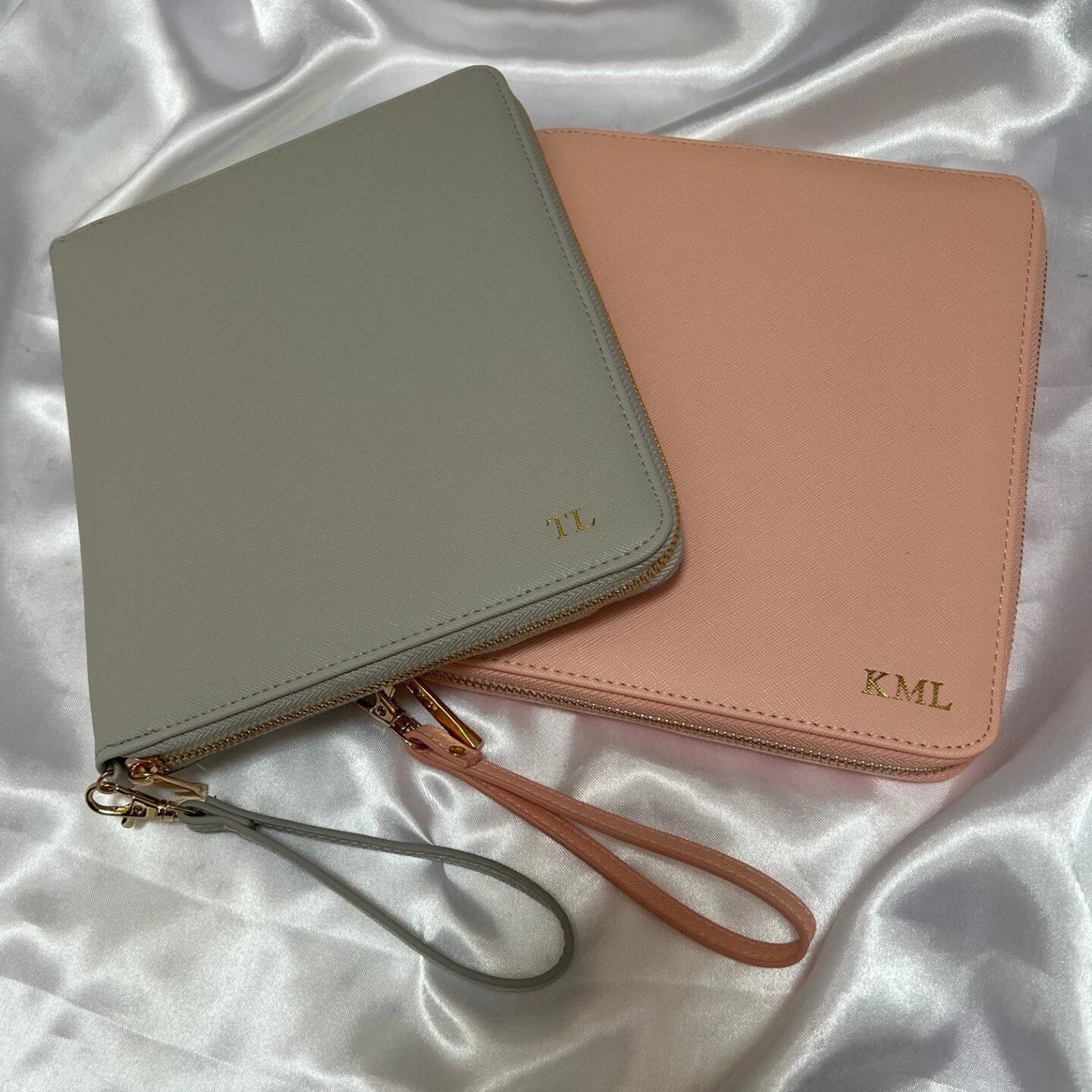 Two personalised travel wallet documents, one in pink and one in grey.