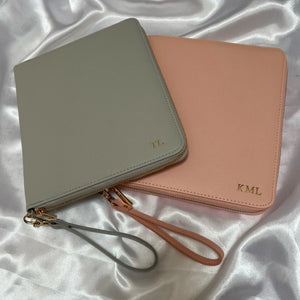 Two personalised travel wallet documents, one in pink and one in grey.