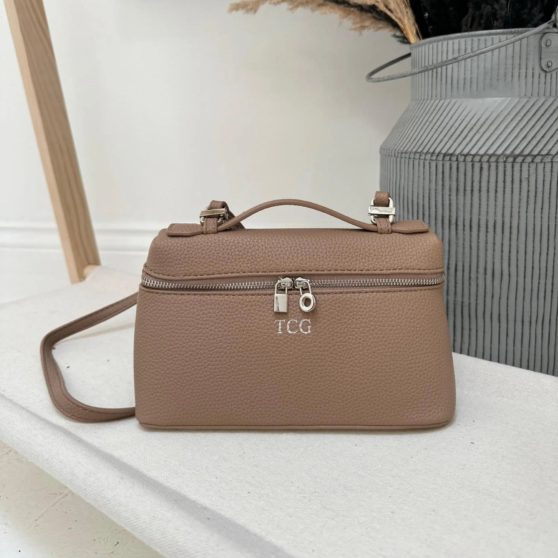 Brown handbag with visible personalisation on a light surface