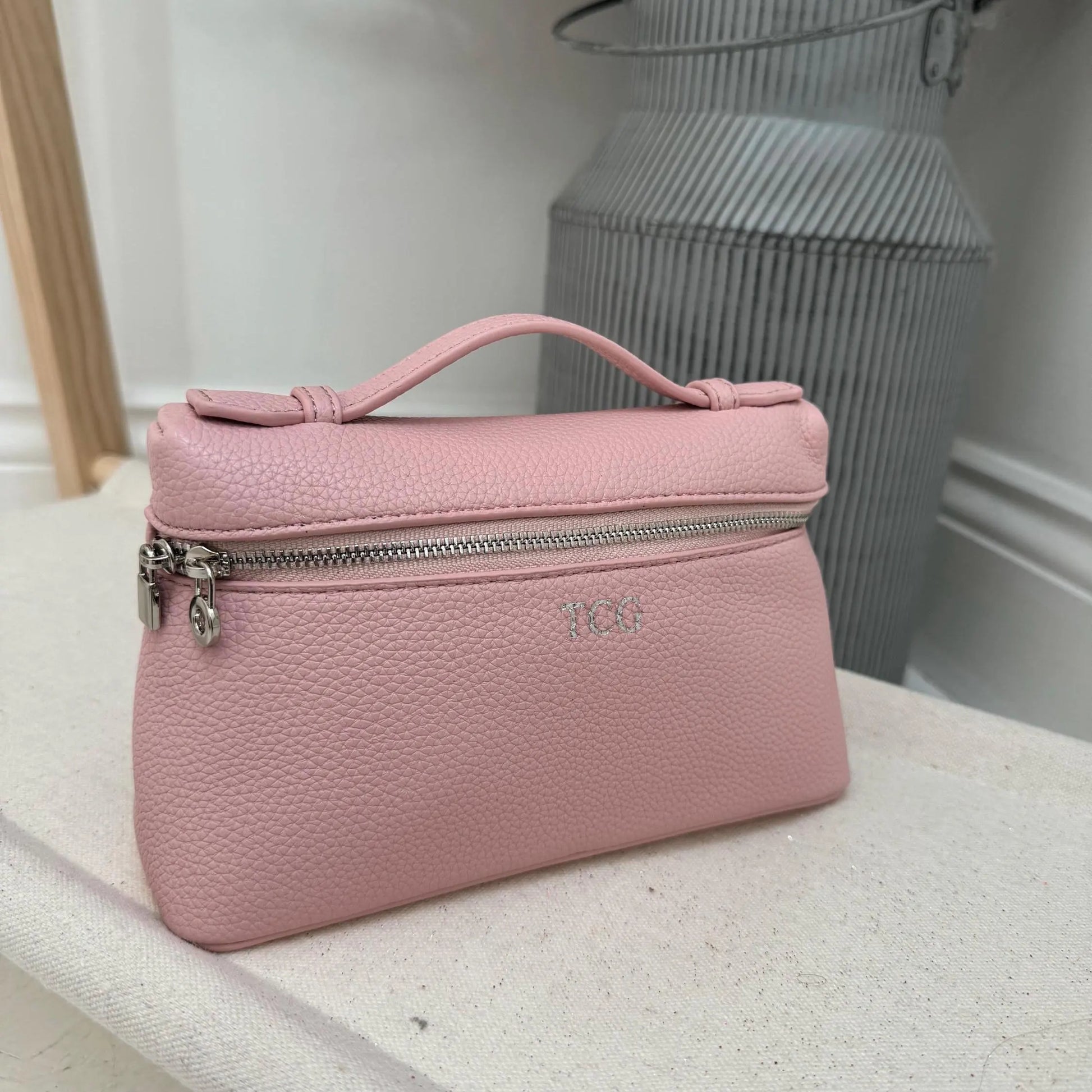 Pink handbag with a visible personalisation on a light surface.
