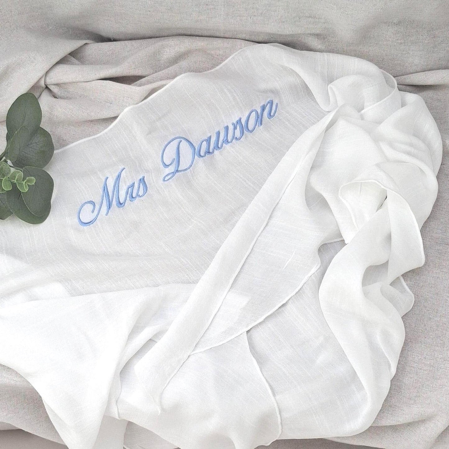 White sarong with 'Mrs. Dawson' embroidery on a light gray background