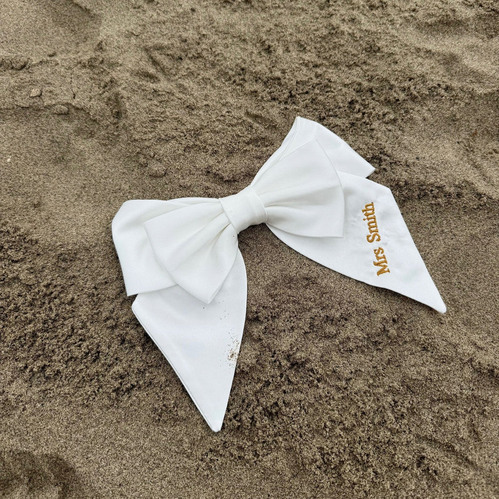 White bow with 'Mrs Smith' label on sand