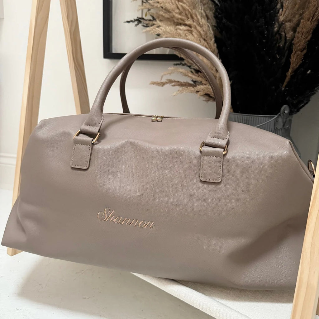 Beige handbag with 'Shannon' branding on a light wooden surface.