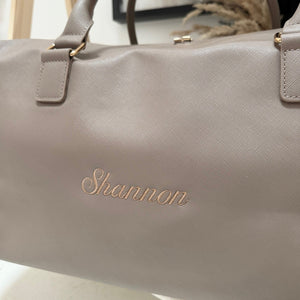 Gray handbag with 'Shannon' embossed on it, on a light background