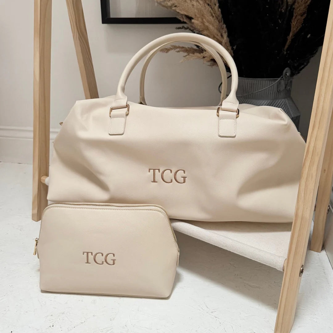Beige weekender and matching washbag with the initials TCG on it