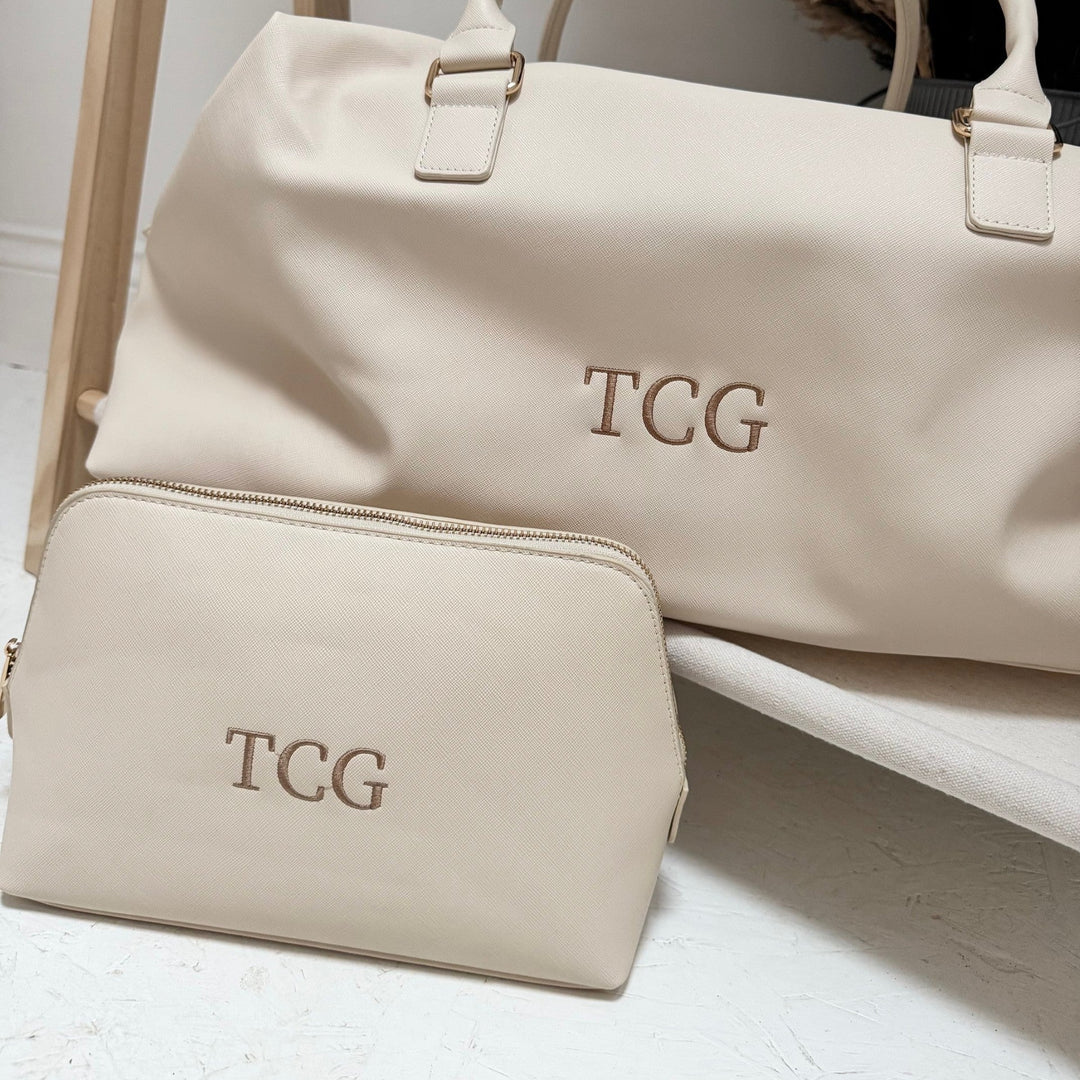 Beige weekender with TCG initials close up and matching washbag