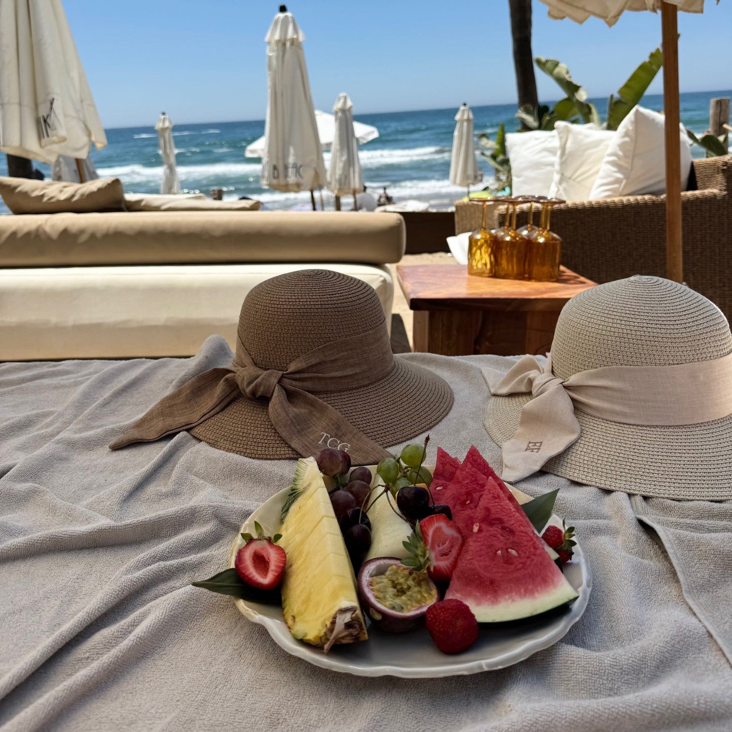 Fruit plate with hats on a beach setting