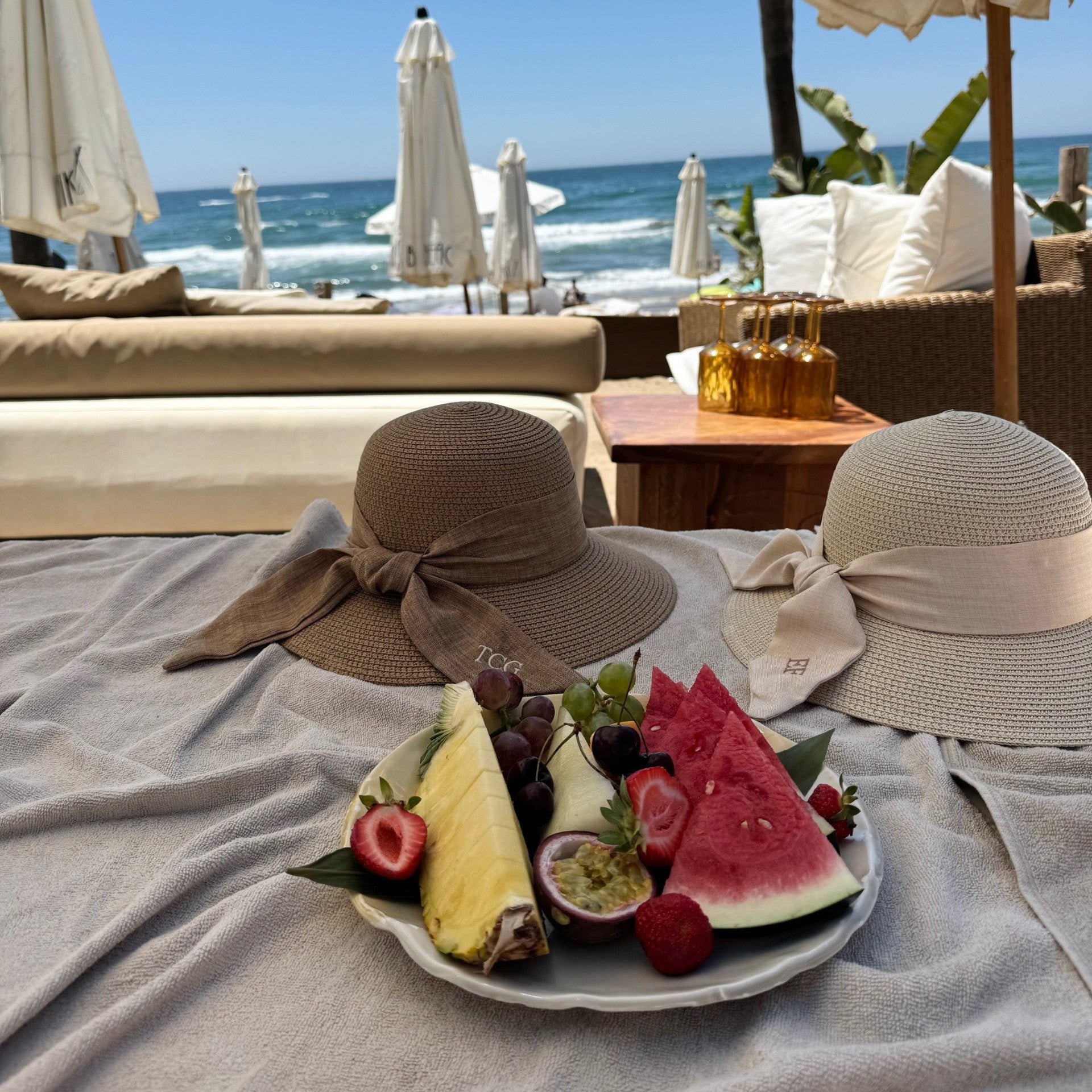 Fruit plate with hats on a beach setting