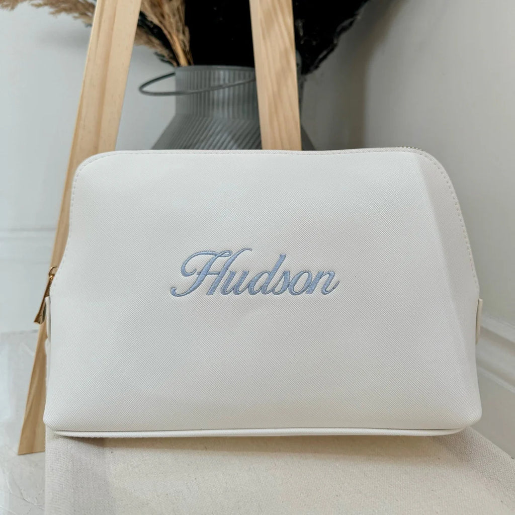 White pouch with 'Hudson' embroidery on a light background