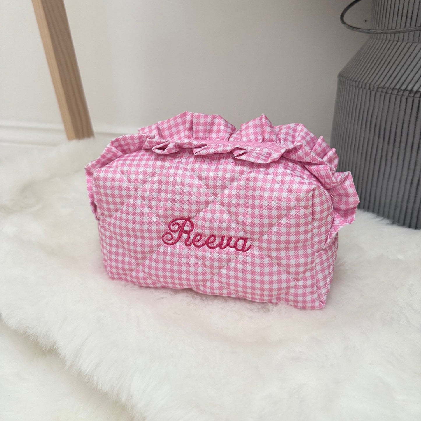 Pink gingham bag with ruffles on a white surface