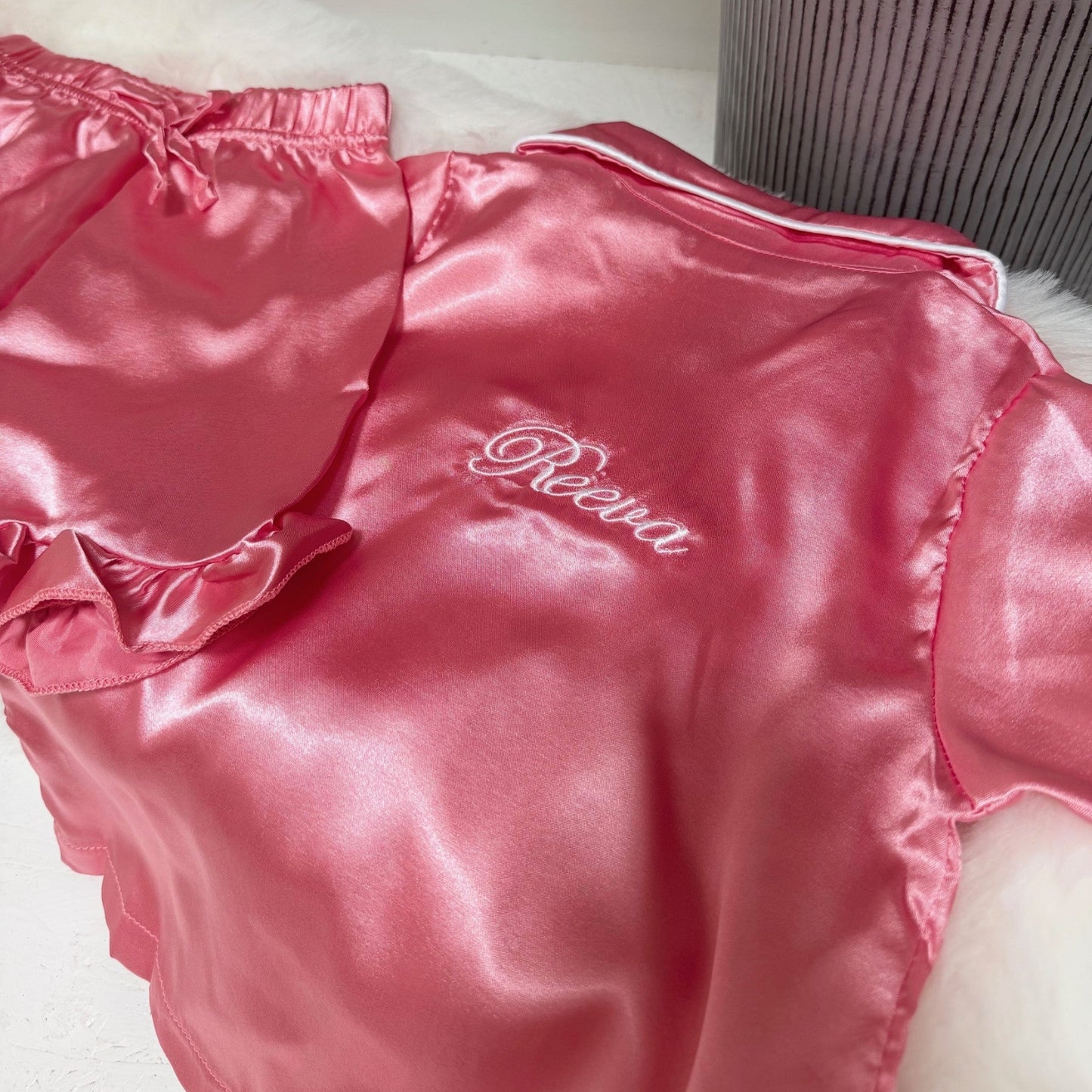 Pink satin kids pjs with 'Reeva' branding on a white background