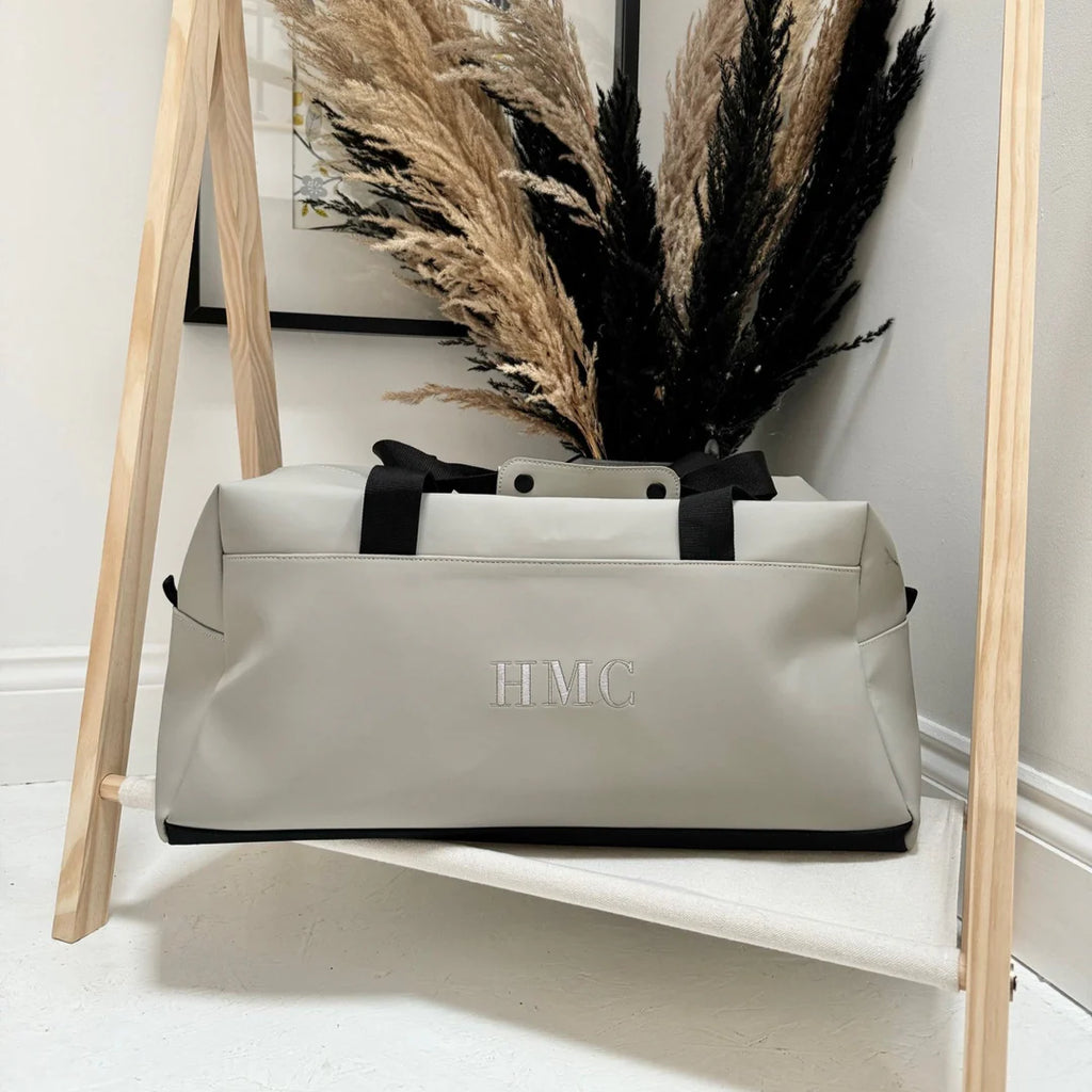 Grey duffle bag with embroidered white initials 