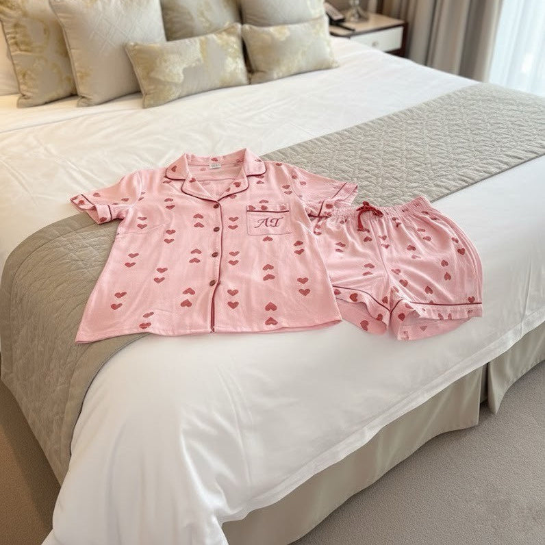 Pink pajama set on a bed in a bedroom setting