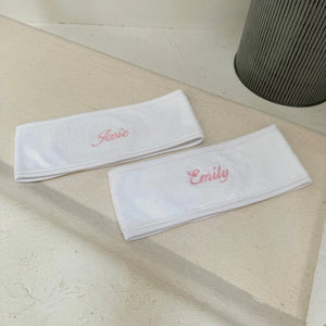 two white spa headbands with personalised names on