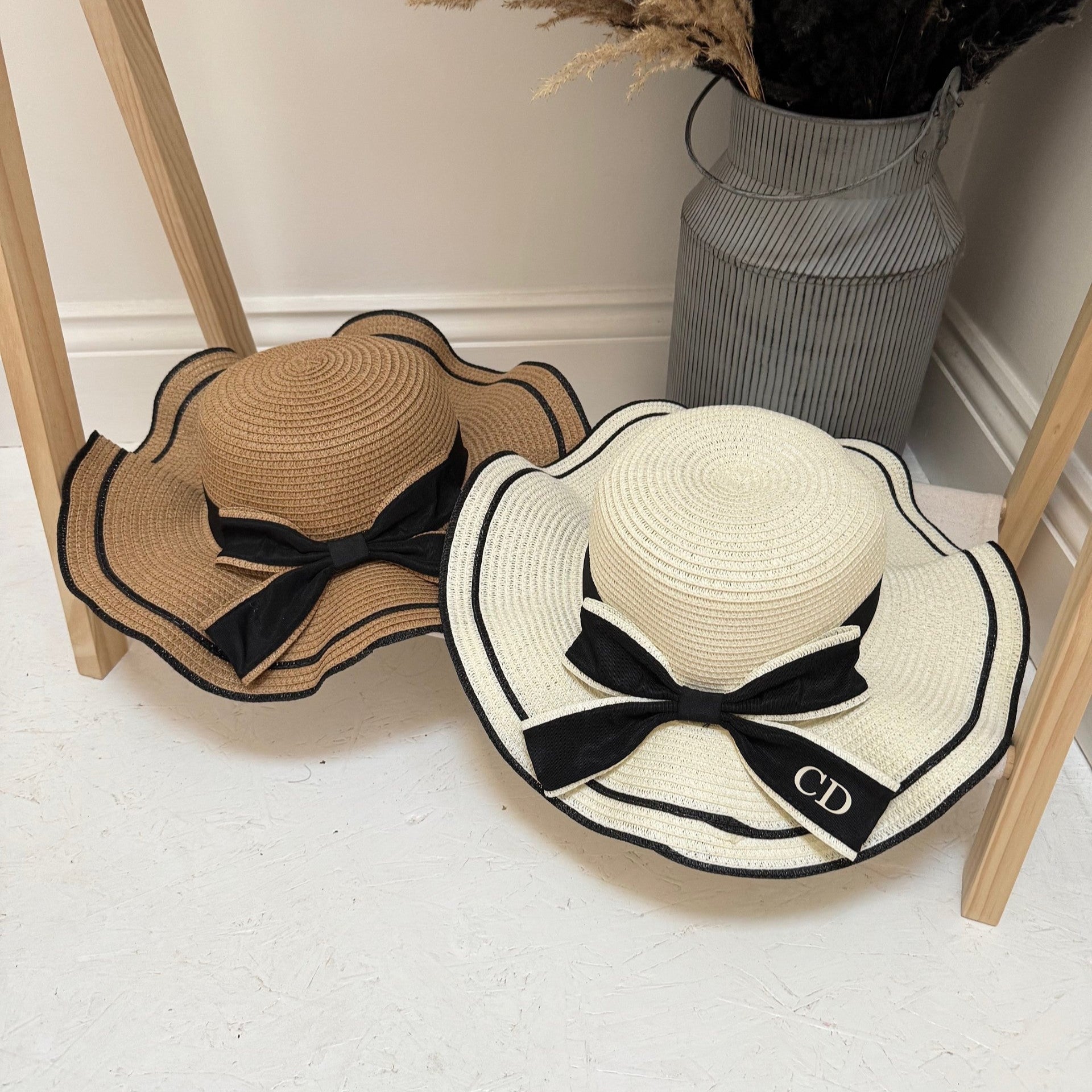 Two straw hats with black bows on a light-colored floor.