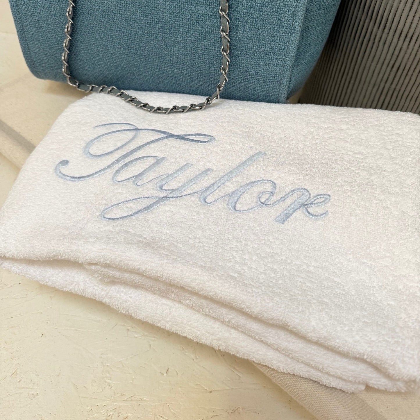  white towel with 'Taylor' monogram on a wooden surface.