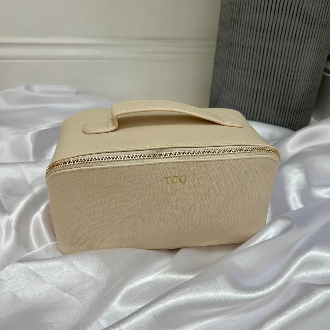 Beige travel case with 'TCG' branding on a white fabric background
