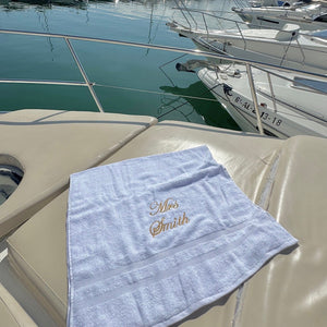 white  towel with 'Mrs. Smith' embroidery on a boat deck