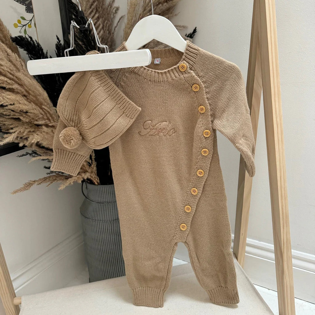 Brown baby romper with buttons on a white surface