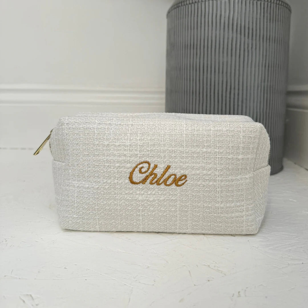 Beige pouch with 'Chloe' embroidery on a white surface