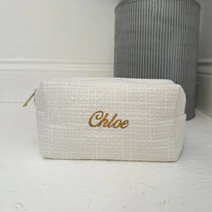 Beige pouch with 'Chloe' embroidery on a white surface