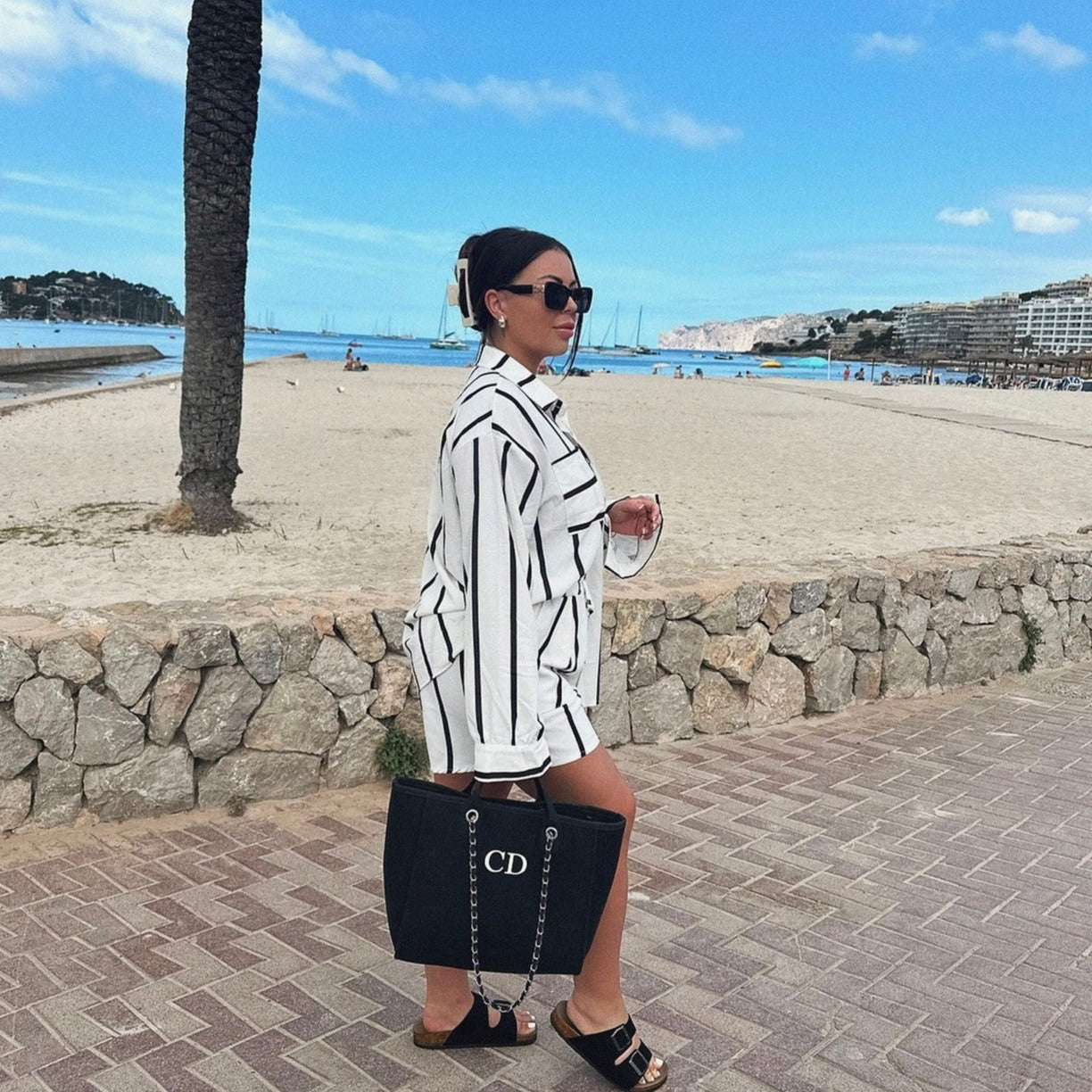 personalised black tote bag held by girl on  the beach