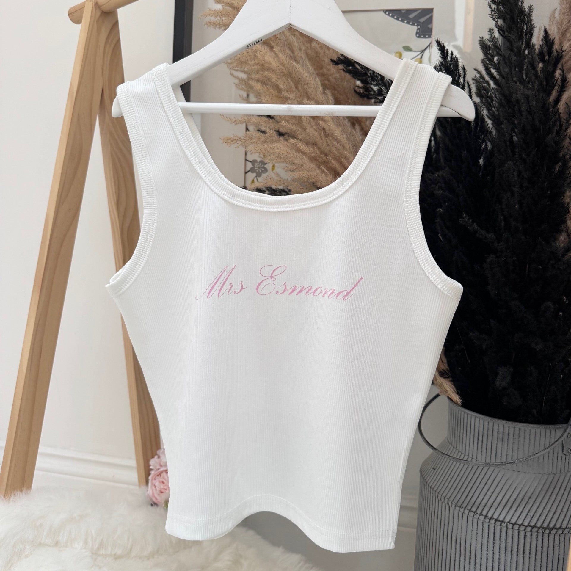 White tank top with bridal title text on a hanger against a neutral background