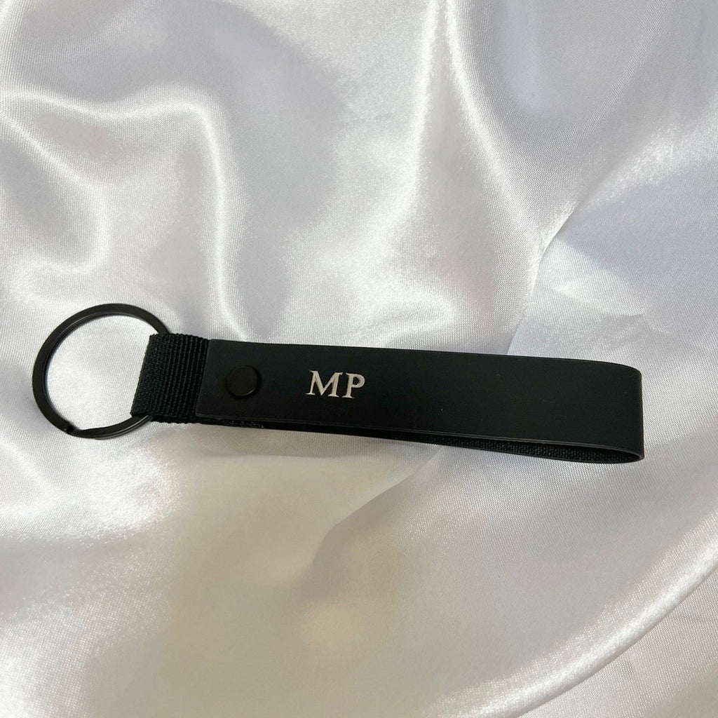 Black keychain with initials 'MP'