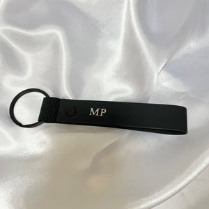 Black keychain with initials 'MP'