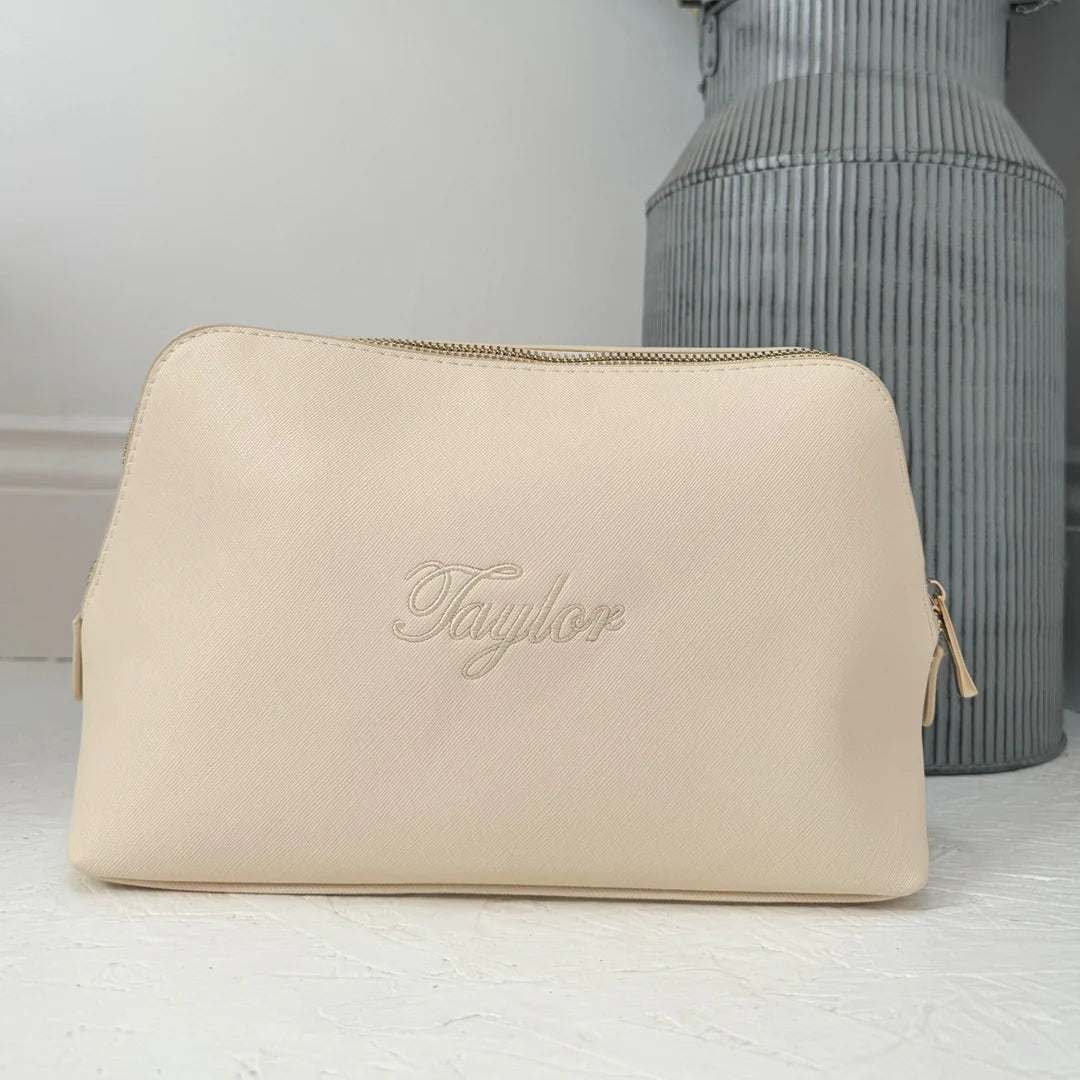 Beige pouch with 'Taylor' branding on a light gray background
