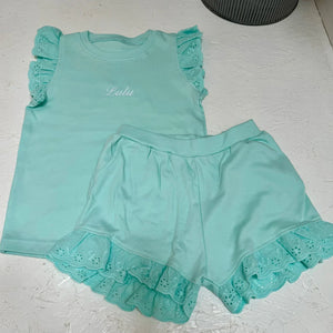 Turquoise children's outfit with ruffled details on with Lulu on it