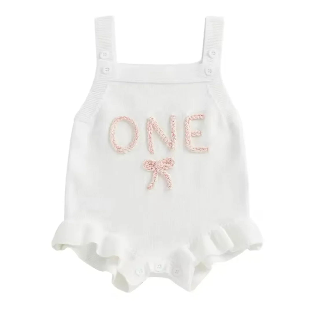 White baby romper with 'ONE' and a bow on a white background