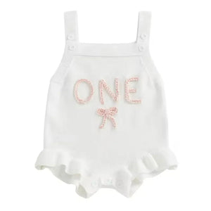 White baby romper with 'ONE' and a bow on a white background
