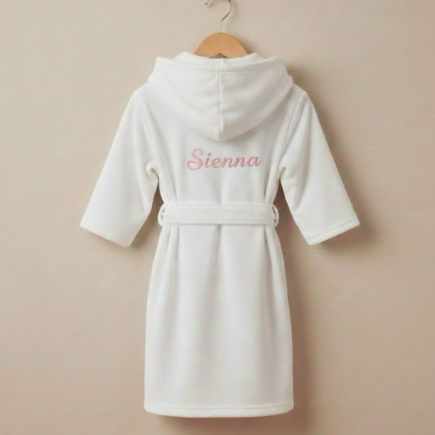 White children's robe with 'Sienna' embroidered on a beige background