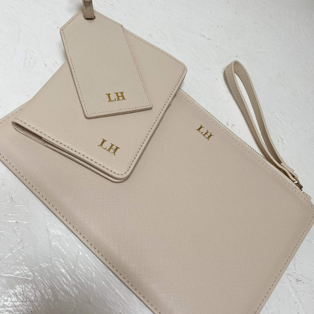 Beige clutch bag with monogram initials matching with a travel set