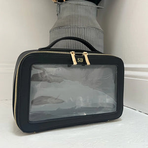 Black cosmetic bag with gold zippers on a white surface with personalised SB
