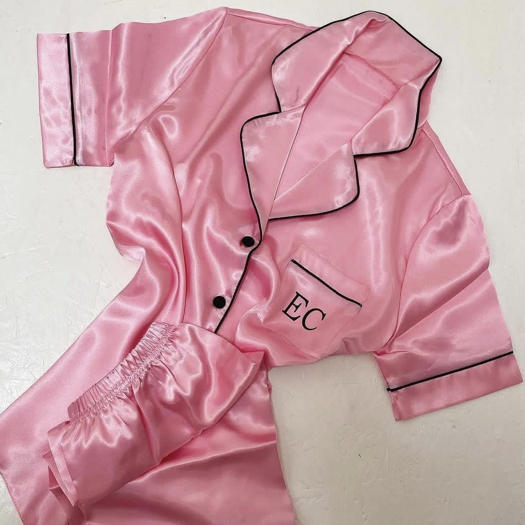 Pink satin pajama set with 'EC' initials on a light background