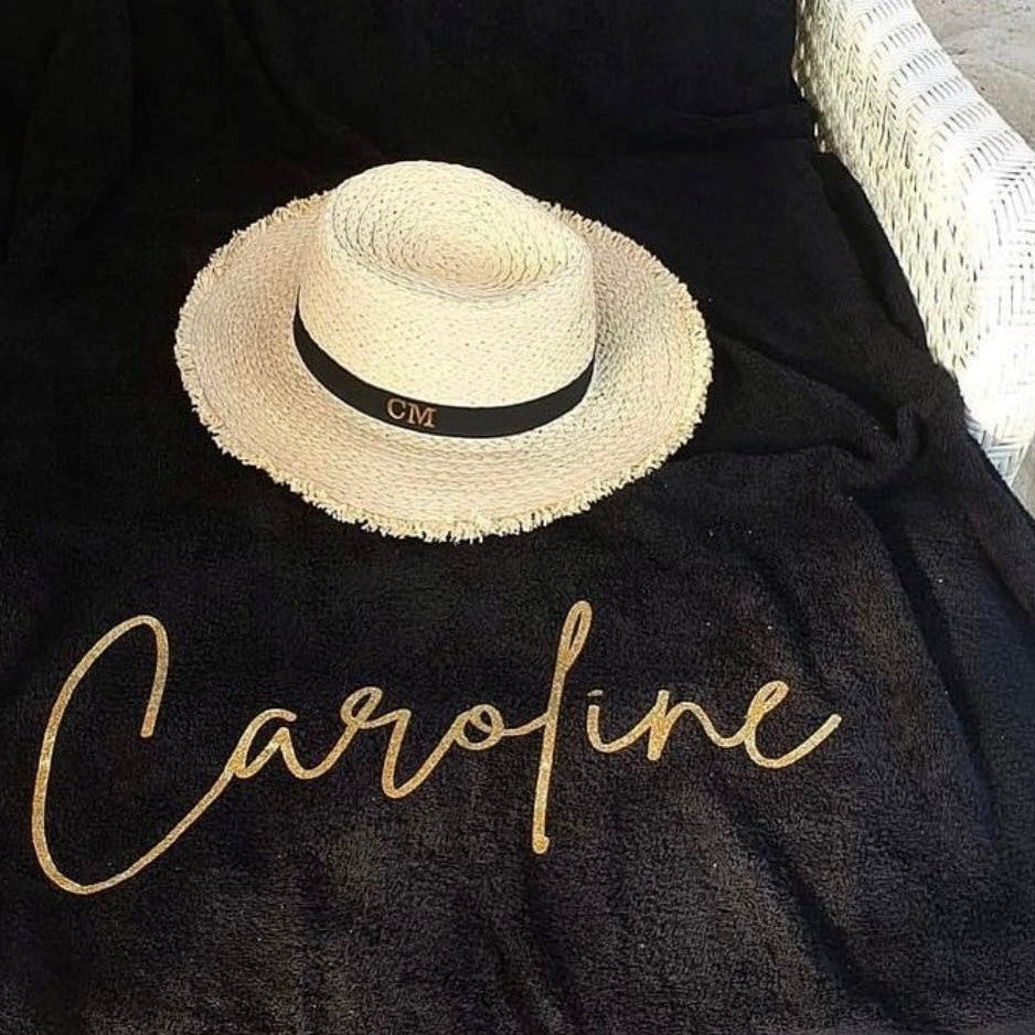 personalised towel with the name Caroline on it with beach hat